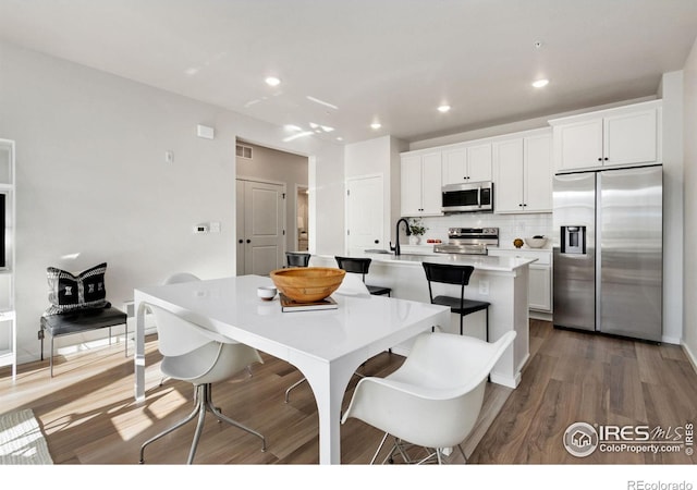 dining space with sink and dark wood-type flooring