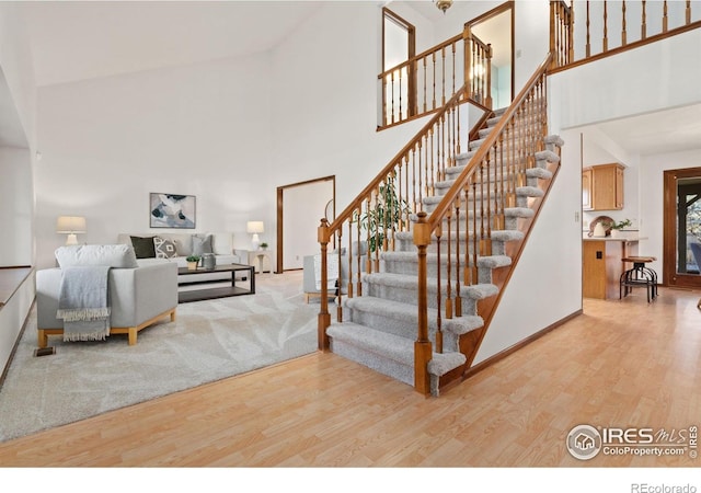 stairs featuring hardwood / wood-style flooring and a towering ceiling