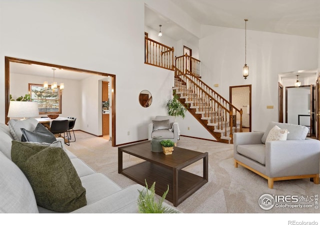 living room featuring a towering ceiling, light colored carpet, and a notable chandelier