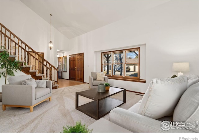 living room featuring light carpet, high vaulted ceiling, and an inviting chandelier