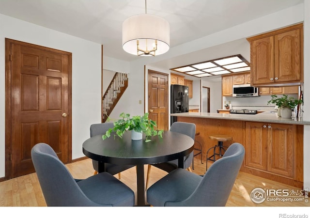 dining area featuring light hardwood / wood-style flooring and a notable chandelier