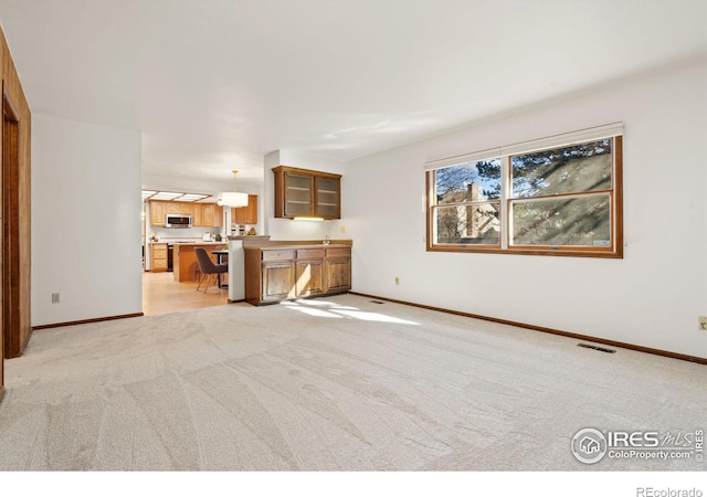 unfurnished living room featuring light colored carpet