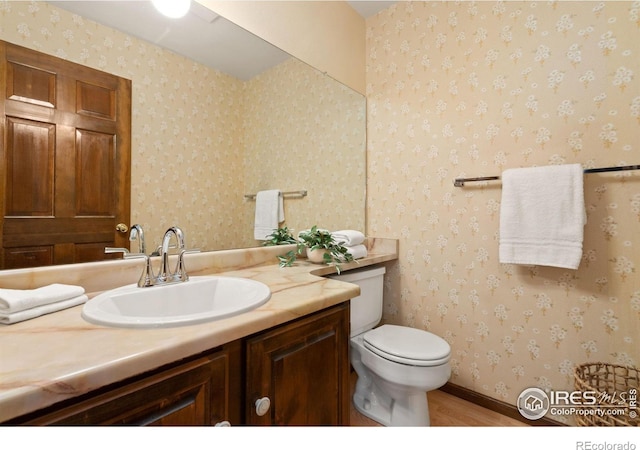 bathroom featuring vanity, toilet, and hardwood / wood-style floors