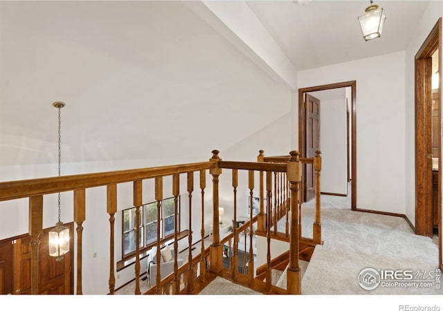 hall featuring vaulted ceiling and light colored carpet