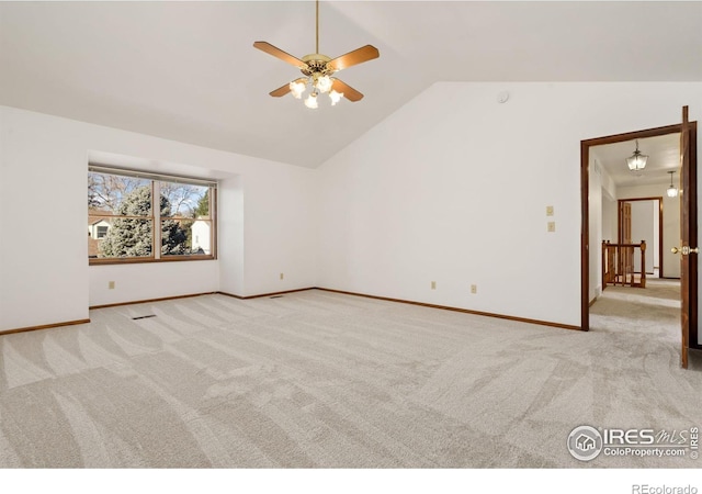 carpeted spare room with ceiling fan and vaulted ceiling