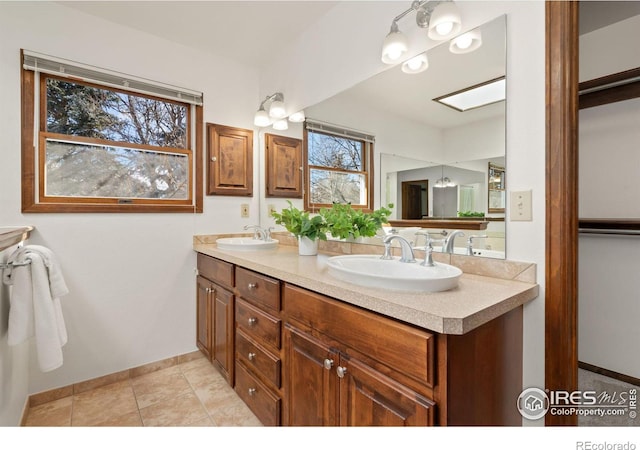 bathroom featuring tile patterned floors, vanity, and a skylight