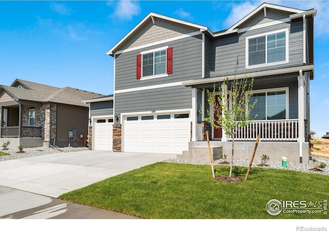 view of front of property with a garage, covered porch, and a front yard