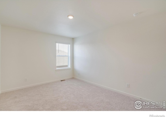 unfurnished room featuring light colored carpet