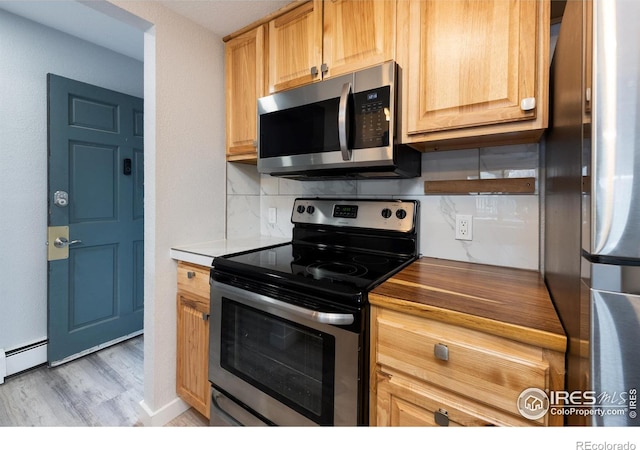 kitchen with tasteful backsplash, a baseboard radiator, appliances with stainless steel finishes, and light hardwood / wood-style flooring