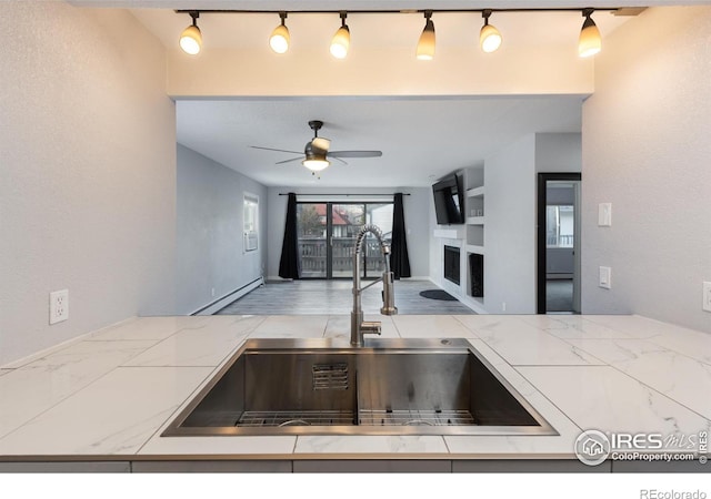 kitchen featuring built in shelves, ceiling fan, and sink