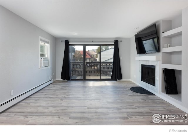 unfurnished living room featuring light hardwood / wood-style flooring, a premium fireplace, cooling unit, a baseboard heating unit, and built in shelves