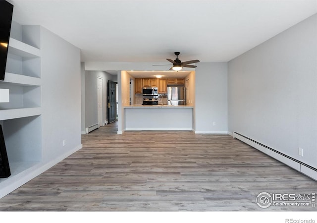 unfurnished living room with a baseboard radiator, light hardwood / wood-style floors, and ceiling fan