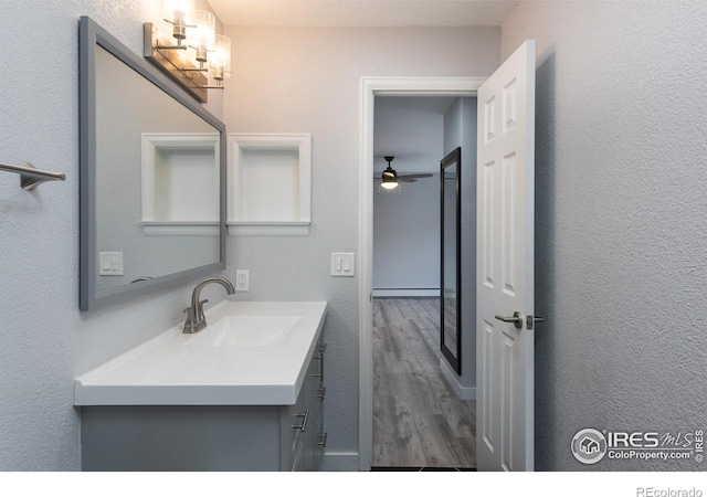 bathroom with vanity, a baseboard heating unit, and hardwood / wood-style flooring