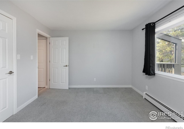 carpeted empty room featuring a baseboard radiator