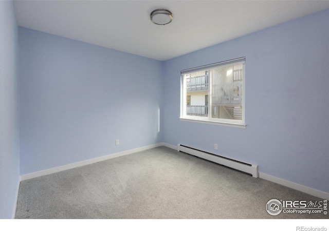 carpeted spare room featuring baseboard heating