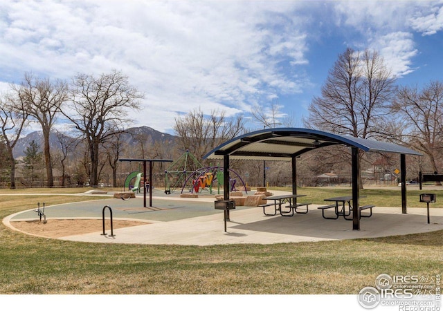 view of community featuring a mountain view, a lawn, and a playground