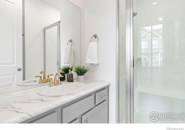 bathroom with vanity and a shower with shower door