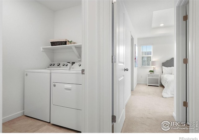 clothes washing area with separate washer and dryer and light colored carpet