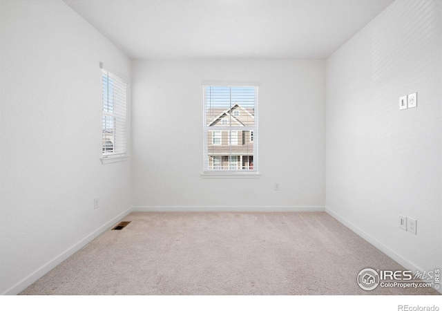 spare room featuring light colored carpet