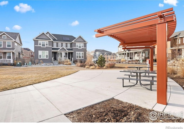 view of home's community featuring a lawn and a pergola