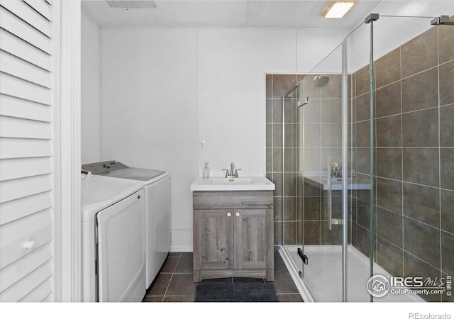 bathroom with vanity, an enclosed shower, washer and clothes dryer, and tile patterned floors