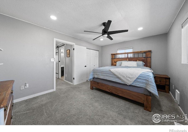 carpeted bedroom with ceiling fan, a textured ceiling, and a closet