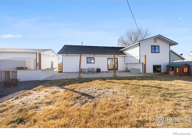 back of property with a patio area and a lawn