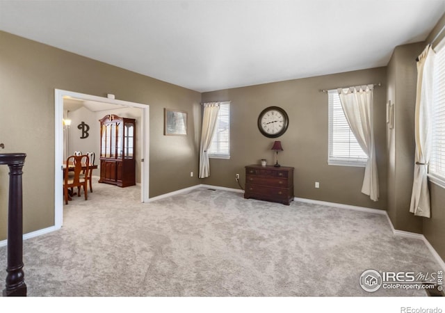 interior space with a healthy amount of sunlight and light carpet