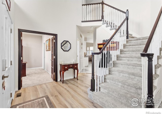 entrance foyer with a high ceiling and light hardwood / wood-style flooring