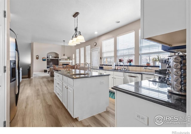 kitchen with appliances with stainless steel finishes, a center island, sink, and white cabinets