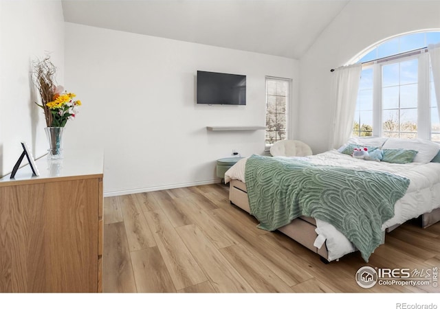 bedroom featuring vaulted ceiling and light hardwood / wood-style flooring