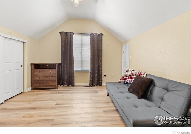 living room featuring vaulted ceiling, ceiling fan, and light wood-type flooring