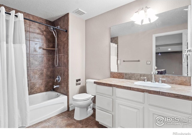 full bathroom featuring shower / tub combo with curtain, vanity, toilet, tile patterned floors, and a textured ceiling