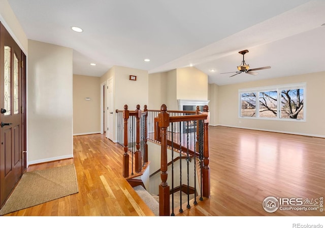 hallway with lofted ceiling and light hardwood / wood-style flooring