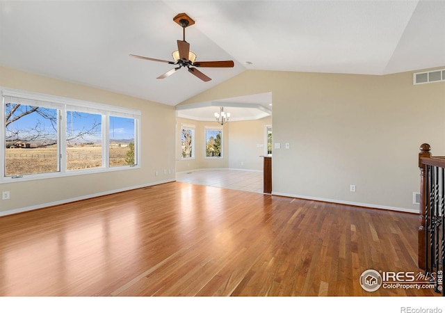 unfurnished living room featuring ceiling fan with notable chandelier, lofted ceiling, and hardwood / wood-style floors