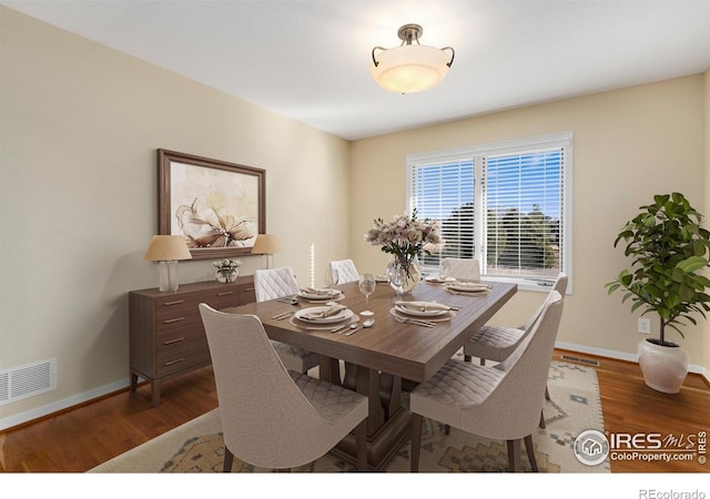 dining space with dark hardwood / wood-style flooring