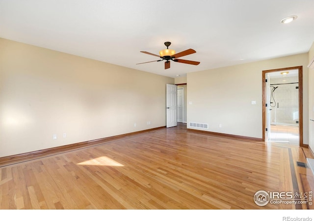 empty room with ceiling fan and light wood-type flooring