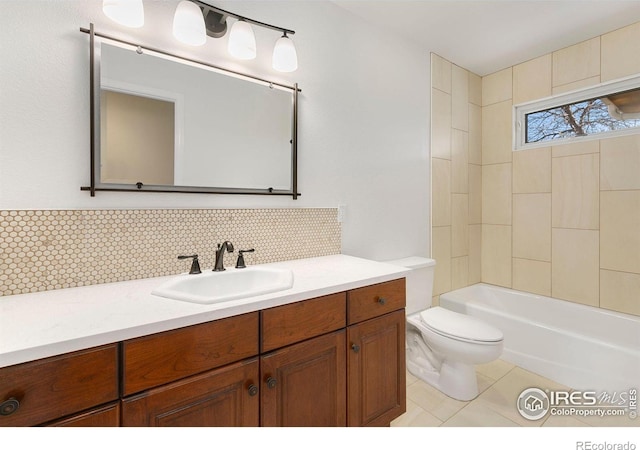 full bathroom featuring tile patterned flooring, tasteful backsplash, vanity, toilet, and tiled shower / bath