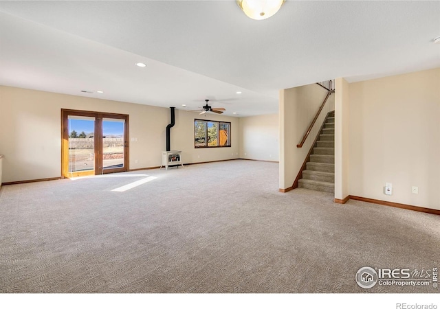 unfurnished living room with a wood stove and light carpet