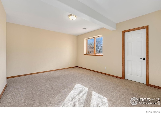 unfurnished bedroom with beam ceiling and light carpet