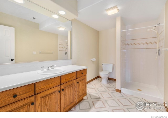 bathroom featuring vanity, toilet, and tiled shower