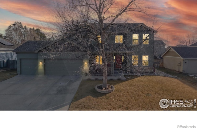 view of front of home with a garage and a yard