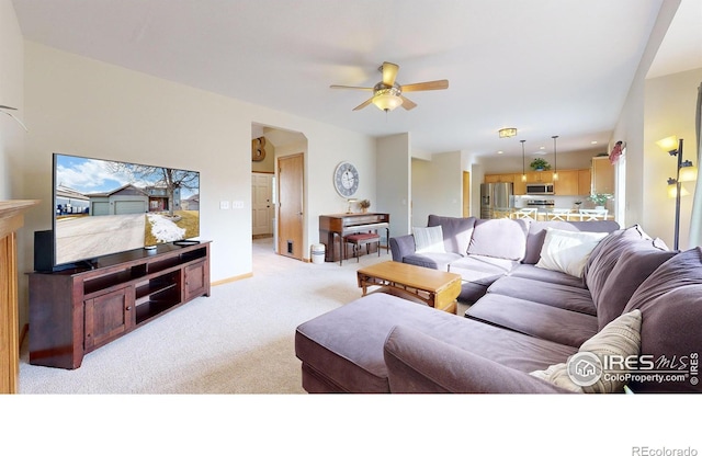 carpeted living room with ceiling fan