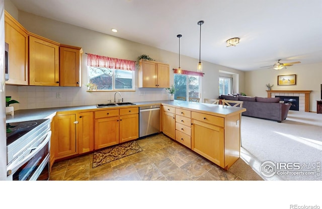 kitchen with appliances with stainless steel finishes, decorative light fixtures, sink, decorative backsplash, and kitchen peninsula