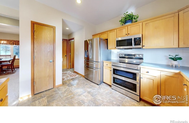 kitchen with tasteful backsplash, appliances with stainless steel finishes, and light brown cabinetry