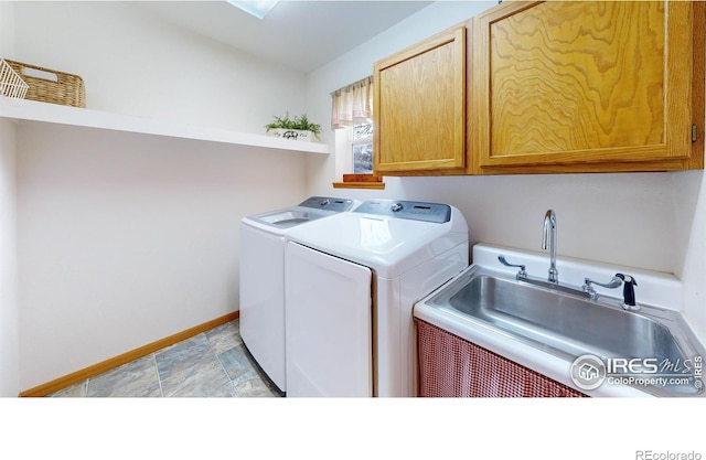 clothes washing area with cabinets, washer and clothes dryer, and sink