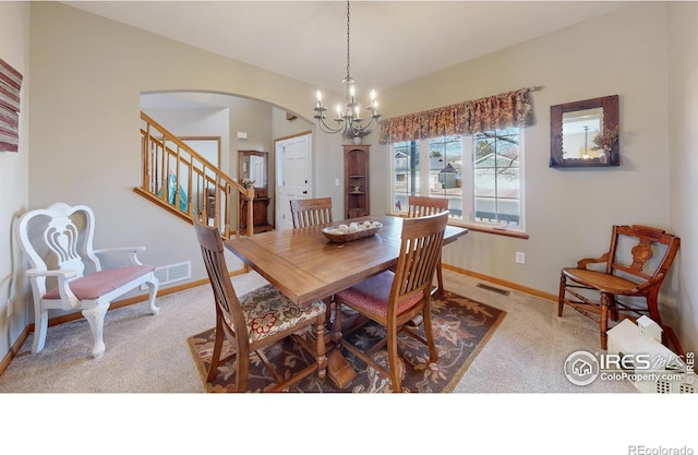 dining area featuring carpet and an inviting chandelier