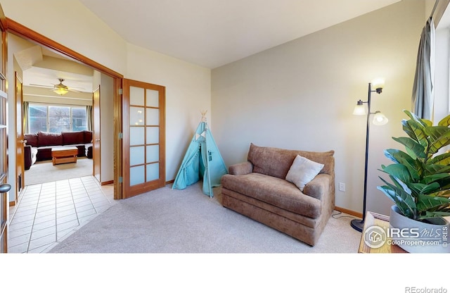 sitting room featuring french doors and light carpet