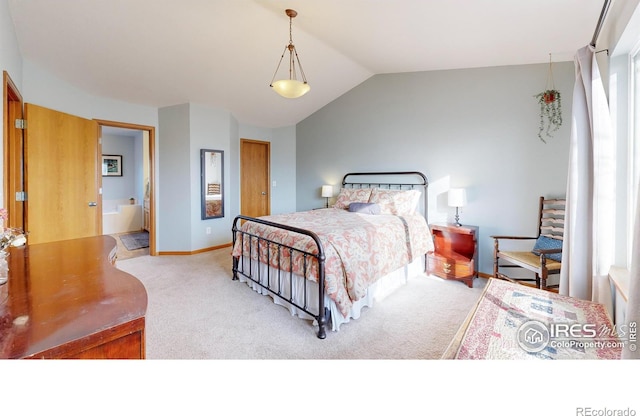 carpeted bedroom featuring vaulted ceiling and ensuite bathroom