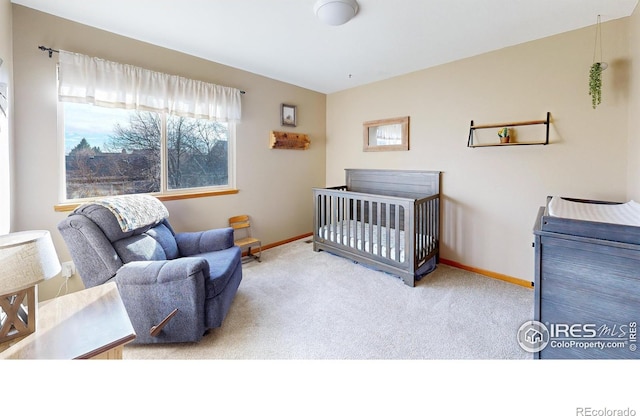 bedroom featuring a nursery area and carpet